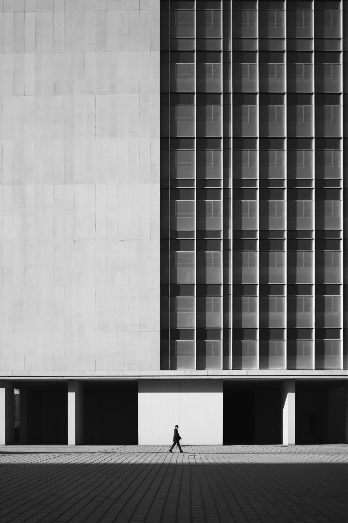 Edifício de concreto em São Paulo, com uma pessoa caminhando na calçada